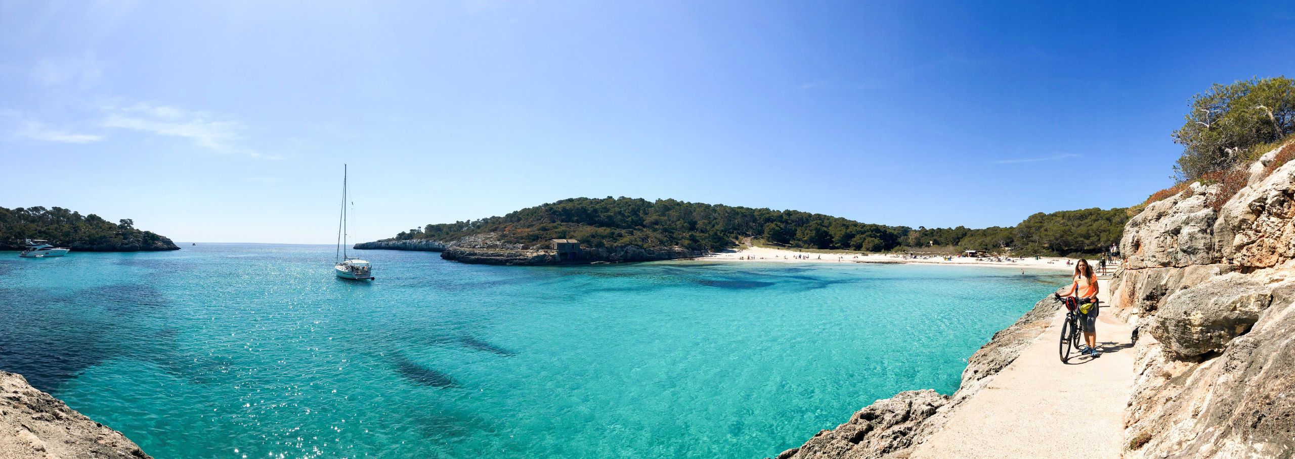 Cala turchese con acque limpide circondata da rocce e alberi a Maiorca.